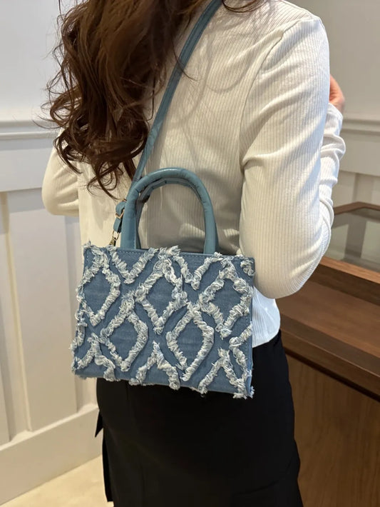 Bolso de mano de cuero sintético con dobladillo deshilachado de mezclilla
