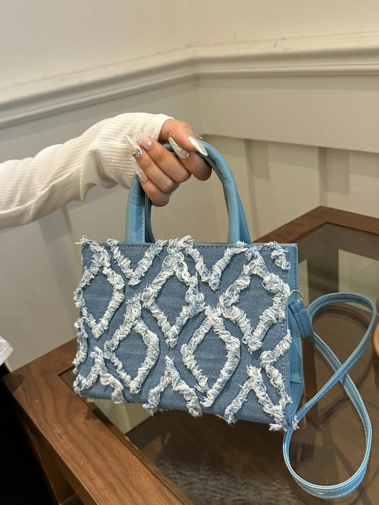Bolso de mano de cuero sintético con dobladillo deshilachado de mezclilla